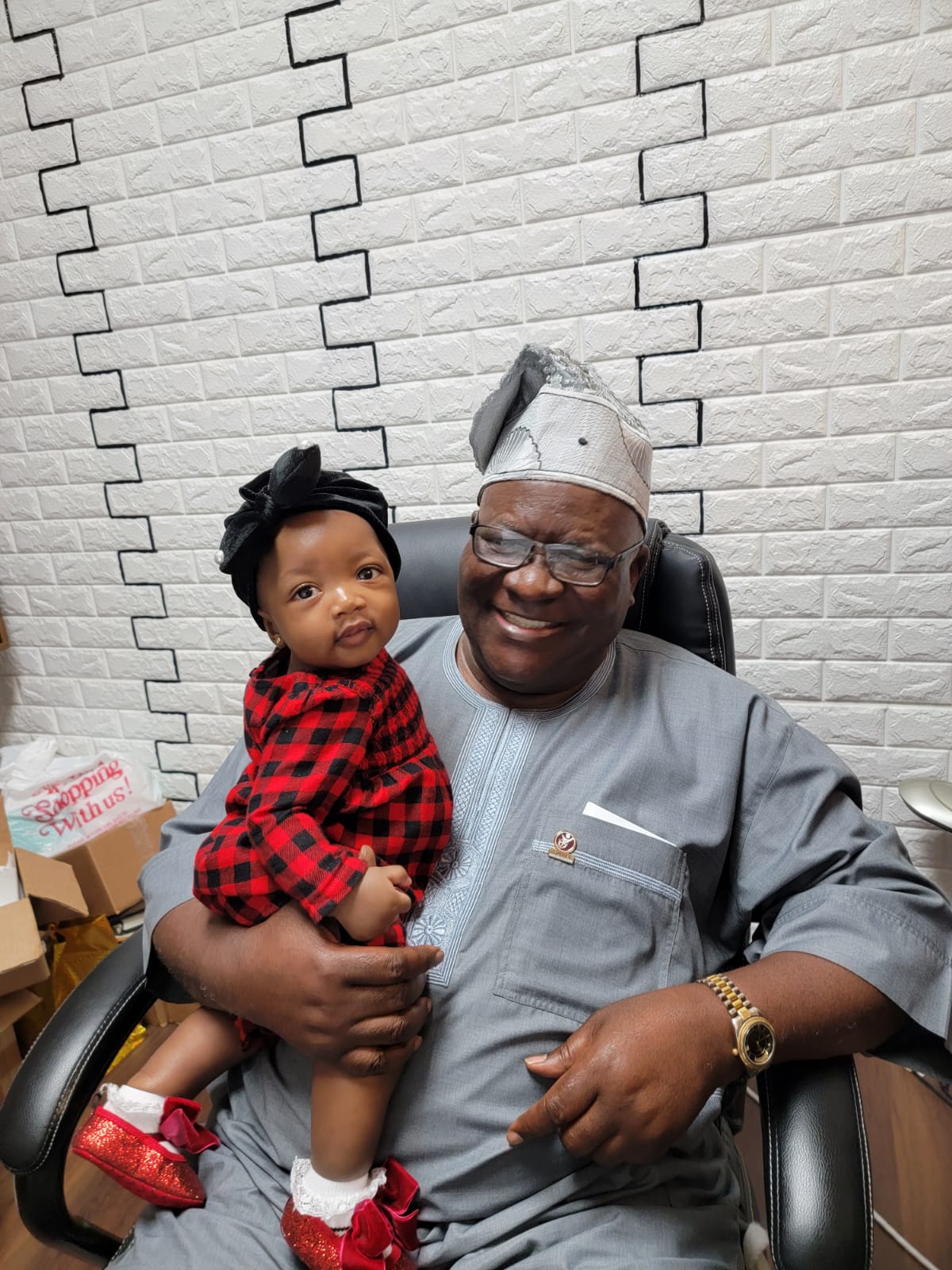 Apostle Odeneye seated with his granddaughter