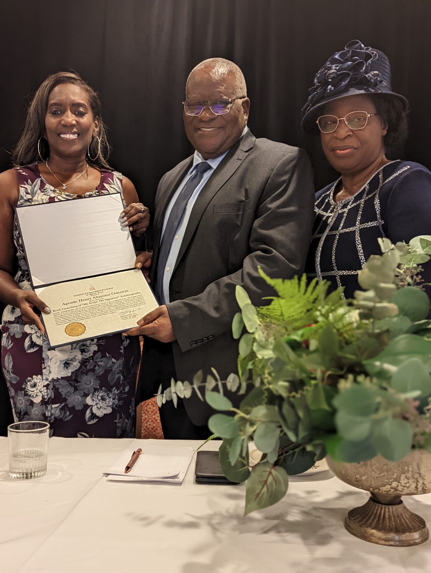 Apostle Odeneye presenting a certificate at the launch of his autobiography