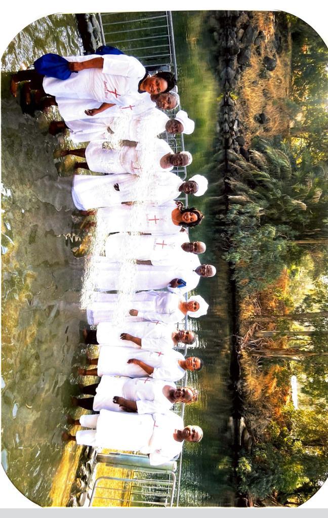Pilgrims in white robes at the River Jordan
