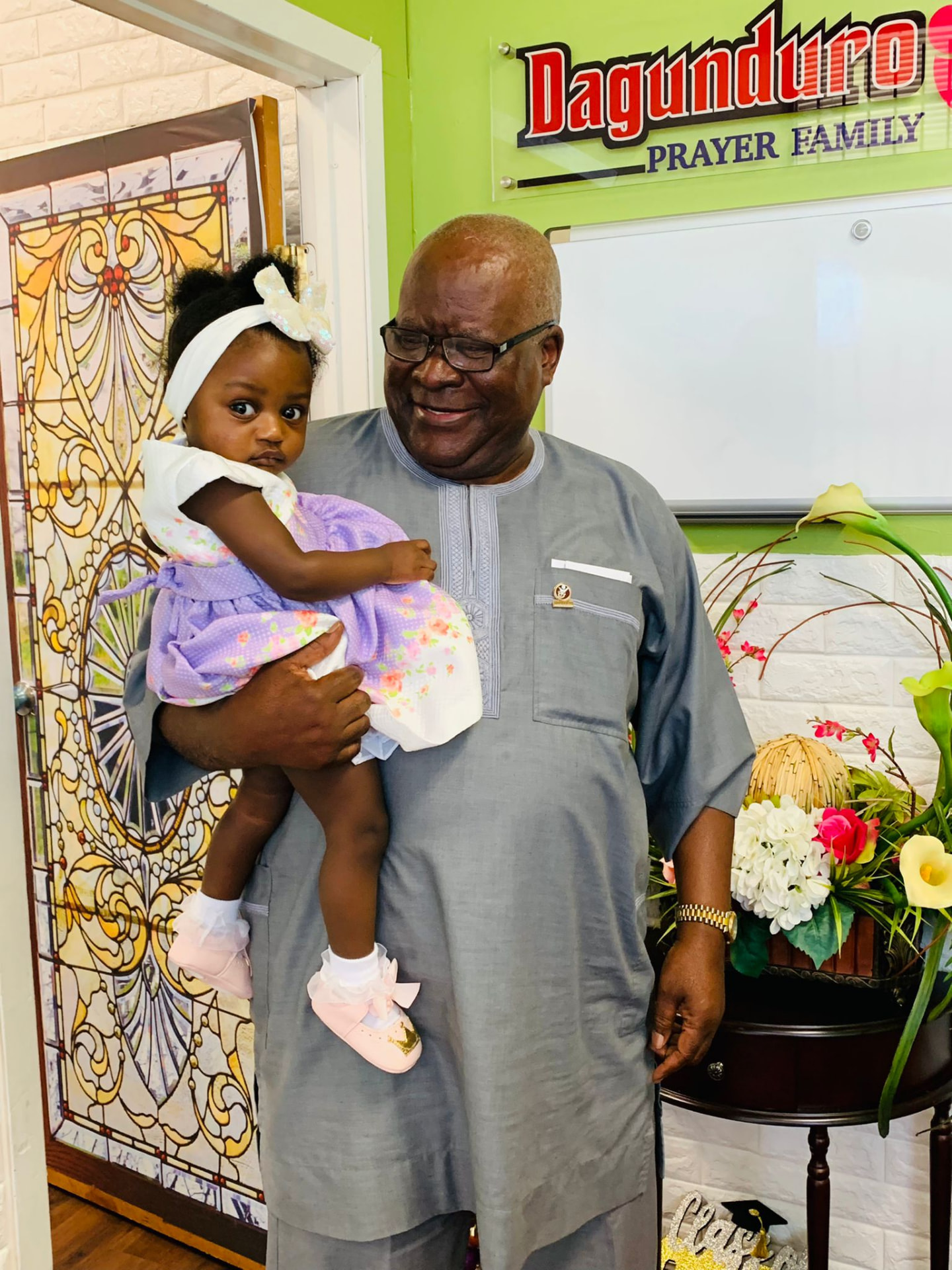 Apostle Odeneye holding his granddaughter